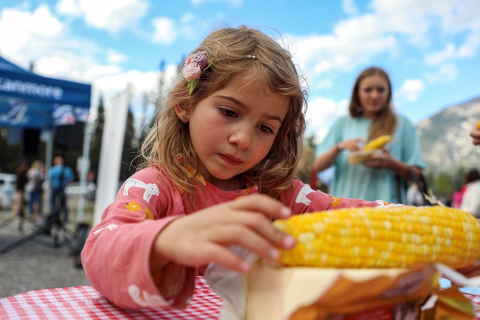 Nya Clark, 6, rolls hot corn over butter at the annual corn hog event hosted by the Bow Valley French Canadian Association (ACFA) at the École Notre-Dame des Monts in Canmore on Thursday (Sept. 7). JUNGMIN HAM RMO PHOTO