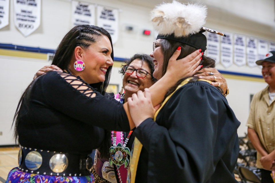 Heather Ketchemonia, left, congratulates Harmony McArthur on her graduation at Mînî Thnî Community School graduation ceremony on Thursday (Sept. 21). JUNGMIN HAM RMO PHOTO  