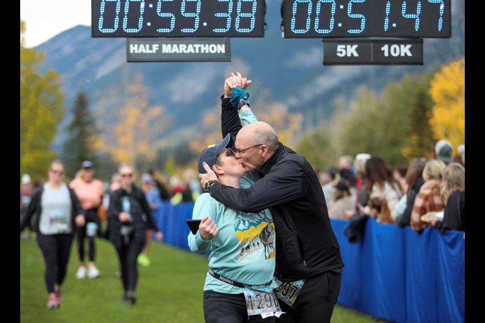 Spruce Grove's Kara Lamoureux left, and Bill Lomax celebrate with a kiss ceremony finishing in the five kilometre race at the 2023 Melissa's Road Race in Banff on Saturday (Sept. 23). JUNGMIN HAM RMO PHOTO