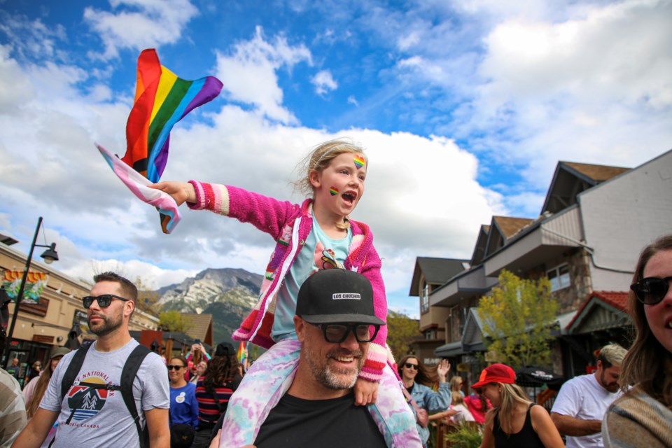 Rosie McPartlin rides on her dad Emmett McPartlin's shoulders and waves Pride flags during the Canmore Pride Unity Walk on Main Street on Saturday (Sept. 23). JUNGMIN HAM RMO PHOTO  
