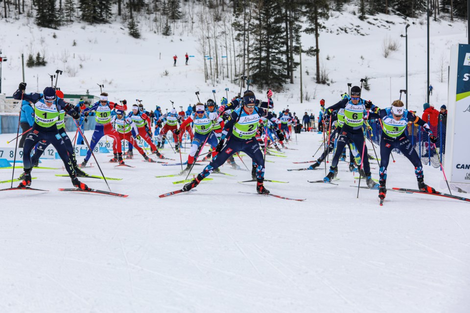 Biathletes ski out of the gate in the men's 15-km mass start at the Canmore IBU Cup at the Canmore Nordic Centre in February 2023. JUNGMIN HAM RMO PHOTO 
