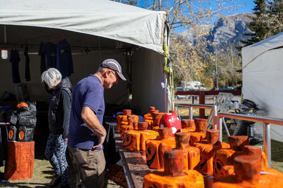 Ron Kubsch appreciates chainsaw-carved pumpkins by local artist Tony Smith at the Canmore Nordic Centre on Friday (Oct. 6). JUNGMIN HAM RMO PHOTO

