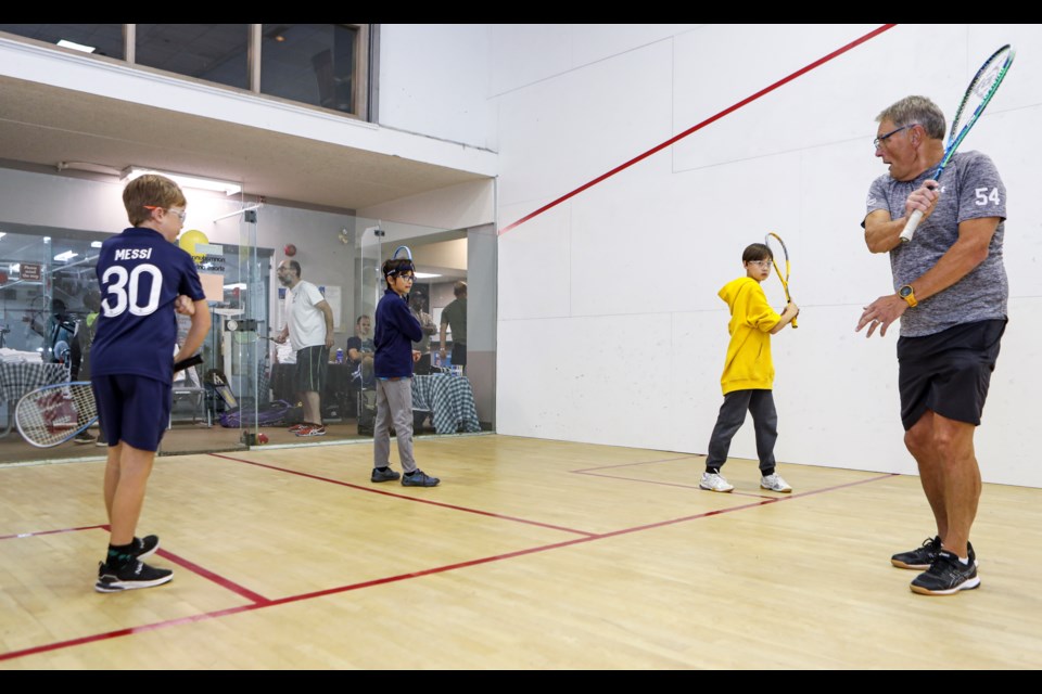 Bruce Gysel, right, teaches Avin Jentzel, 10, left, Leo Hendryanto, 10, and Jonah Squires, 11, the backhand of squash at a 'try-it' squash program hosted by the Bow Valley Squash Foundation at the Banff Rocky Mountain Resort in Banff on Thursday (Oct. 13). JUNGMIN HAM RMO PHOTO