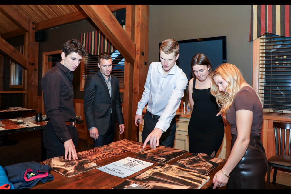 Canada's senior national biathletes look at the Canada's senior national biathlon team's signature edition wood wall arts during the Shoot for Gold fundraiser auction at Iron Goat in Canmore on Thursday (Oct. 19). From left: Zachary Connelly, Chritian Gow, Logan Pletz, Benita Peiffer and Jenna Sherrington. JUNGMIN HAM RMO PHOTO