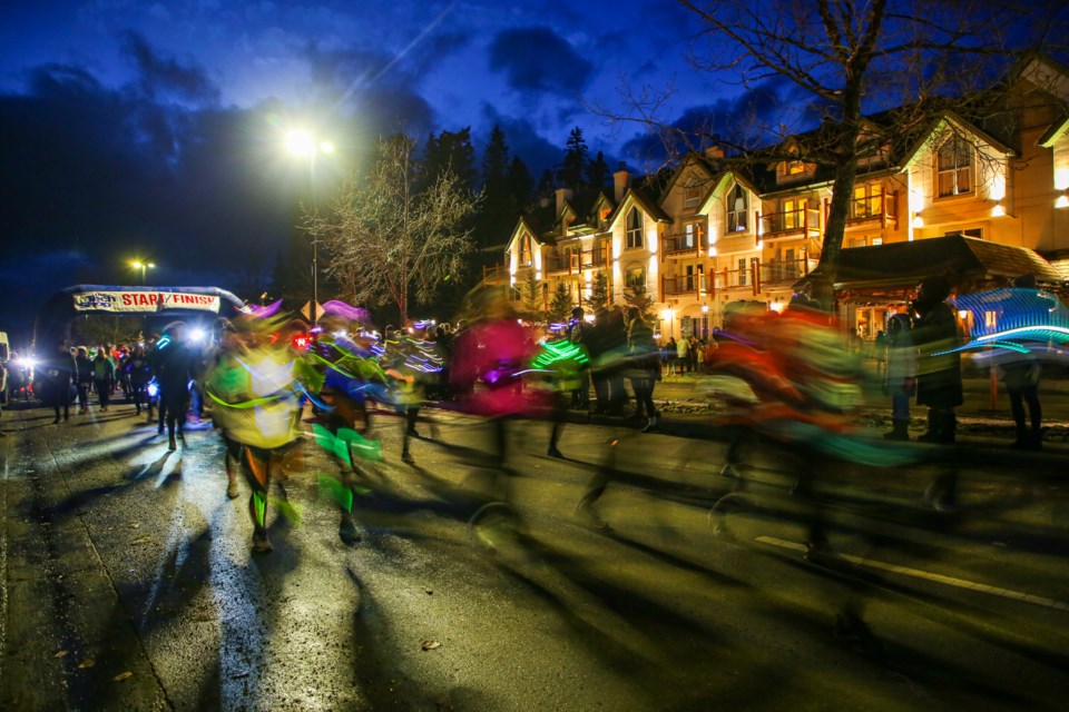 A long exposure shows 1,100 racers blast off from the start gate of the 2023 Banff Winterstart 5 Miler Night Run on Banff Avenue in front of the Rundlestone Lodge on Saturday (Nov. 4). JUNGMIN HAM RMO PHOTO