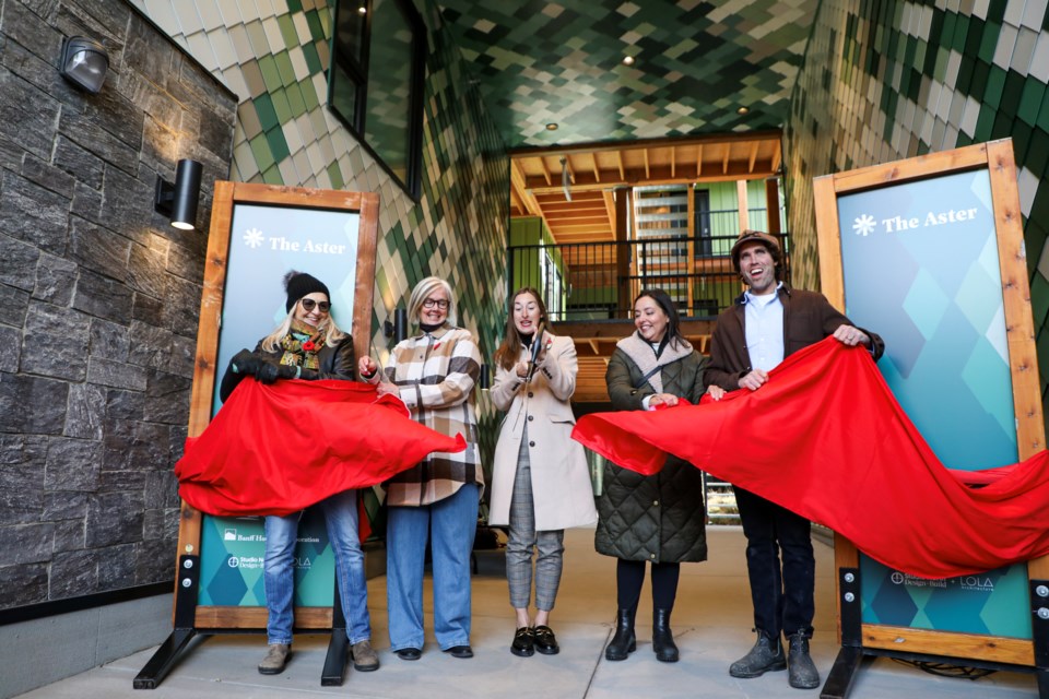 Banff Mayor Corrie DiManno, middle, cuts a ribbon at the ribbon-cutting ceremony marking the completion of The Aster condo in Banff Avenue on Thursday (Nov. 9). From left: Karen Thomas, new resident of The Aster and longtime Banff resident, Sharon Oakley, manager of housing sustainability for the Town of Banff, Maria Landry, principal of Lola Architecture, Matt Kennedy of Studio North design and construction. JUNGMIN HAM RMO PHOTO