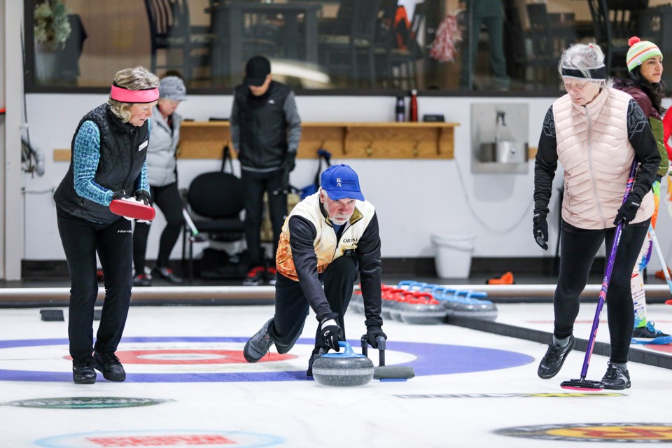 Randy Nichols slides a stone during the mixed bonspiel at the Canmore Golf and Curling Club on Saturday (Nov. 18). JUNGMIN HAM RMO PHOTO