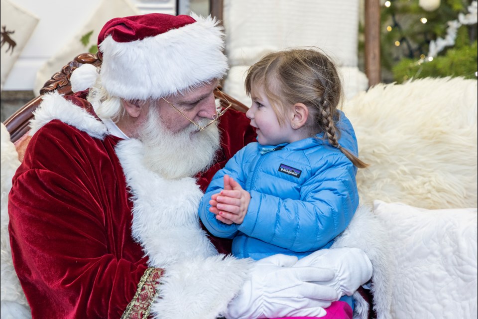 Adeline Watson, 2, brings her hands together and tells Santa Claus she's hoping to get on Christmas day at the Banff Christmas Market on Friday (Nov. 24). JUNGMIN HAM RMO PHOTO