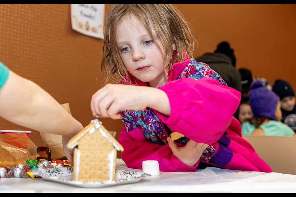 April Brown, 5, decorates a gingerbread house at the Canmore Public Library on Saturday (Dec. 16). JUNGMIN HAM RMO PHOTO  