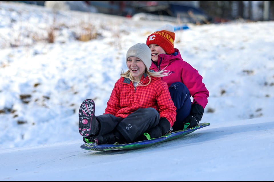 Lexington Gaze, left, and Hailey Labrecque sled down a snowy hill at the Canmore Nordic Centre on Thursday (Jan. 4). JUNGMIN HAM RMO PHOTO 
