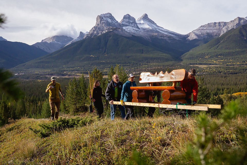 Mountain Muskox and Alpine Club of Canada members cart a 300-pound log memorial bench up a path near the Alpine Club of Canada's Canmore Clubhouse. PETER HOANG ALPINE CLUB OF CANADA 