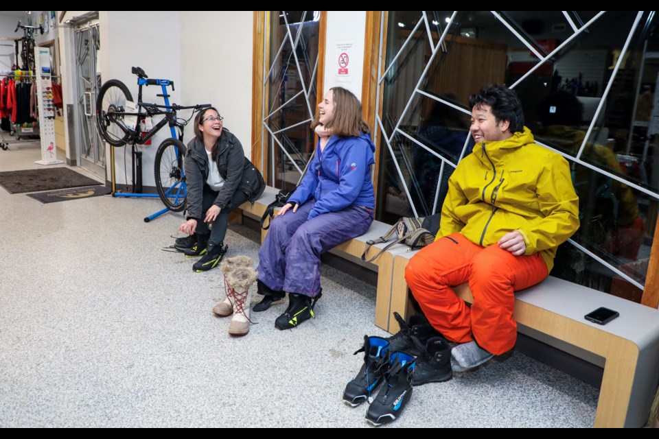 Cynthia Rojas, left, Anne Geerts, centre, and Enrico Estorninos have fun while wearing cross-country skate skiing boots at Trail Sports in Canmore on Thursday (Jan. 25). JUNGMIN HAM RMO PHOTO 