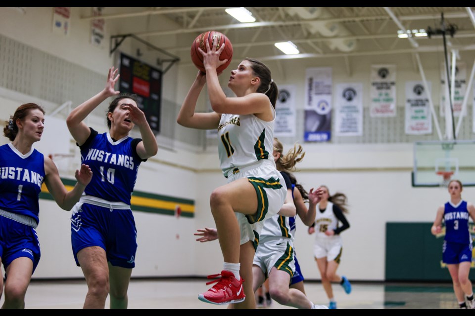 Canmore Wolverines Jordan Lakusta (No. 11) goes for a layup against the Highwood Mustangs during the Rocky Mountain Classic senior girls basketball tournament at Canmore Collegiate High School on Friday (Feb. 2). JUNGMIN HAM RMO PHOTO 