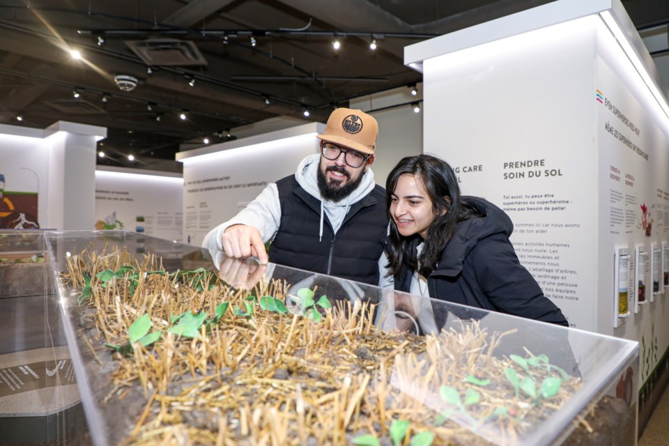 Phillip DaCosta, left, and Honey Gupta from Edmonton appreciate the science of soil at the Canmore Museum new exhibit “Soil Superheroes” on Wednesday (Feb. 3). JUNGMIN HAM RMO PHOTO