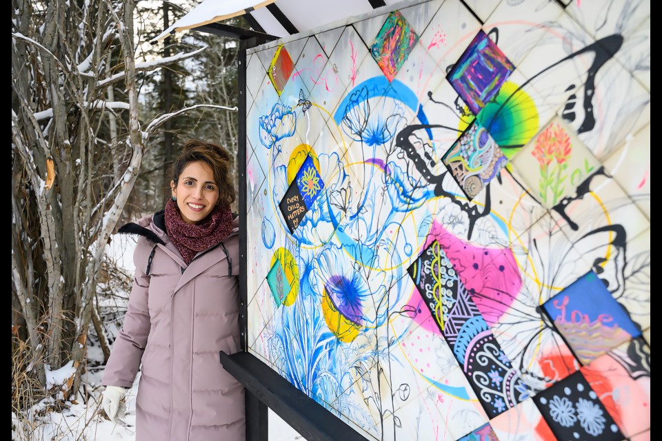 Tara Vahab's poses with her art piece, "Circles as Communities", on the Spur Line Trail for the Art Walk in the Woods in Canmore on Monday (Feb. 5). MATTHEW THOMPSON RMO PHOTO