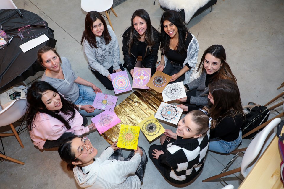 Participants pose with their mandala drawings after the mandala-making class at CanMore Together on Thursday (March 14). A Mandala (Sanskrit for “circle”) is an artistic representation as a geometric symbol used in spiritual, emotional, or psychological work. JUNGMIN HAM RMO PHOTO