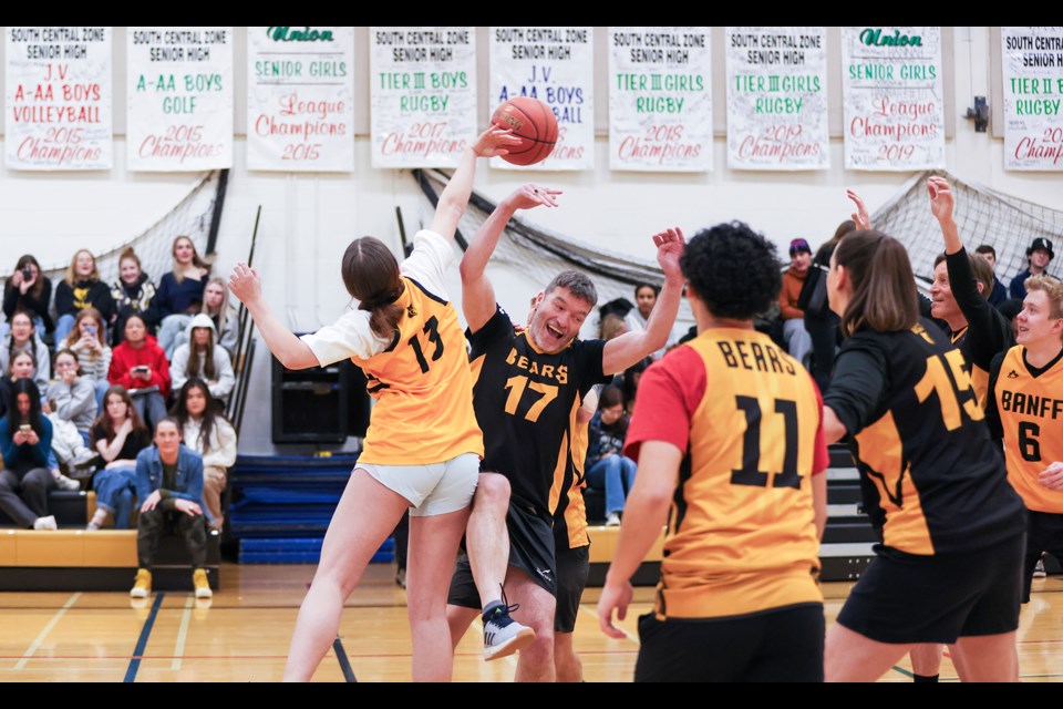 Banff Bears senior team's Grace Gibson, left, and all-stars staff and coaches team's Marc Geestman compete at center court for the jump ball at Banff Community High School on Thursday (March 28). JUNGMIN HAM RMO PHOTO