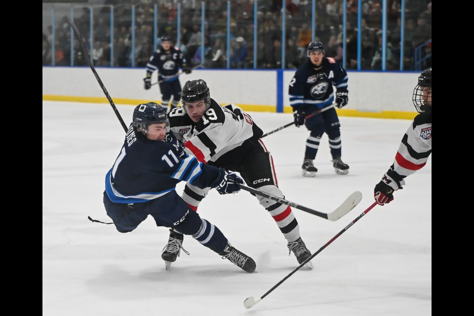 Canmore Eagles center Owen Jones follows through on a shot while being pushed down during a game against the Whitecourt Wolverines in Canmore on Tuesday (April 2). The Eagles lost 2-5 against the Wolverines. The series now favours the Wolverines 2-1. MATTHEW THOMPSON RMO PHOTO