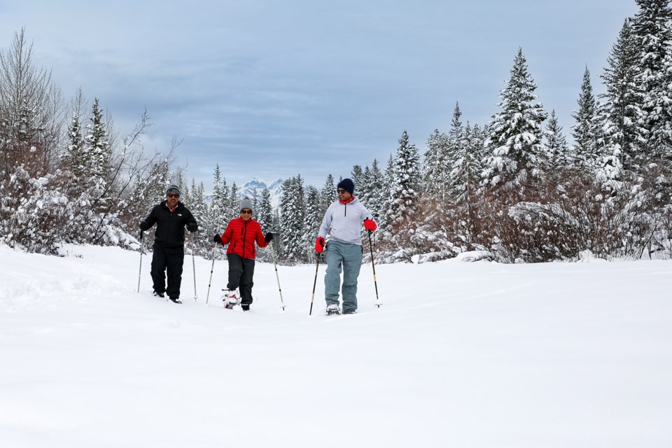 Rajiv Midha, left, Kavita Ahuja and Samir Ahuja go through one of the snow-laden tributaries while snowshoeing on the Bow River in Canmore on Friday (April 5). JUNGMIN HAM RMO PHOTO