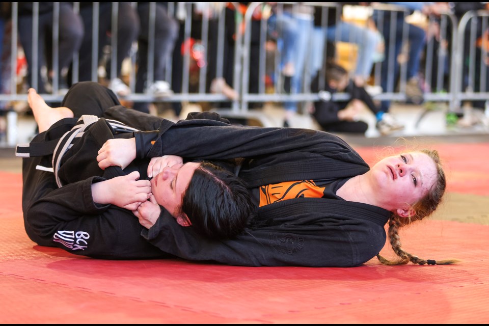 Dark Horse Martial Arts' Aven McKay, right, tries to submit Limitless BJJ Edmonton's Londyn Lefebvre in the back mount in a super fight during the Dark Horse Grappling Series, a submission-only jiu-jitsu tournament at Fenlands Banff Recreation Centre on Saturday (April 13). JUNGMIN HAM RMO PHOTO 