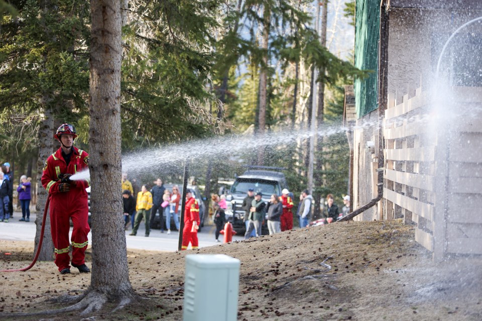 Banff firefighter Vincent Parkinson shoots water into a virtual ignition point during the exercise a response to wildfire approaching the community at Valleyview neighbourhood in Banff on Tuesday (April 23). JUNGMIN HAM RMO PHOTO
