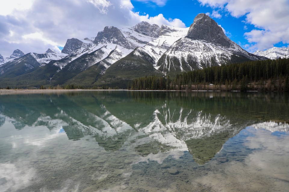 Mountains reflect on water at the beginning of spring season at Rundle Forebay Reservoir in Canmore on Saturday (April 27). JUNGMIN HAM RMO PHOTO