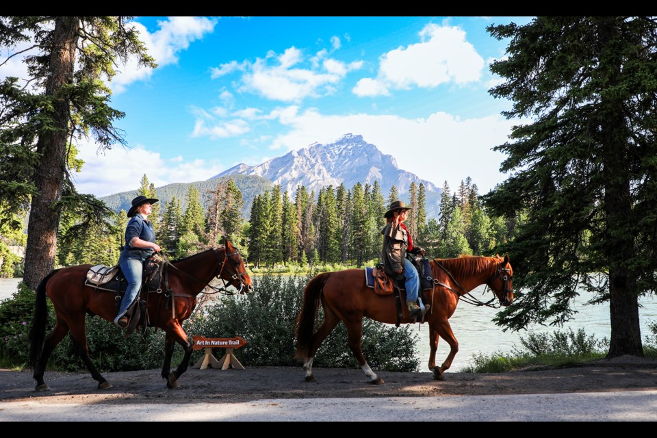 Banff Trail Riders' horses and riders stroll past the Art in Nature Trail, located along the Bow River Trail in Banff on Thursday (July 4). JUNGMIN HAM RMO PHOTO 