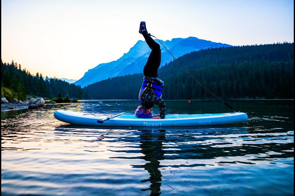 Lucy Hill does yoga on a paddleboard as the sun rises at Two Jack Lake in Banff National Park in August. JUNGMIN HAM RMO PHOTO