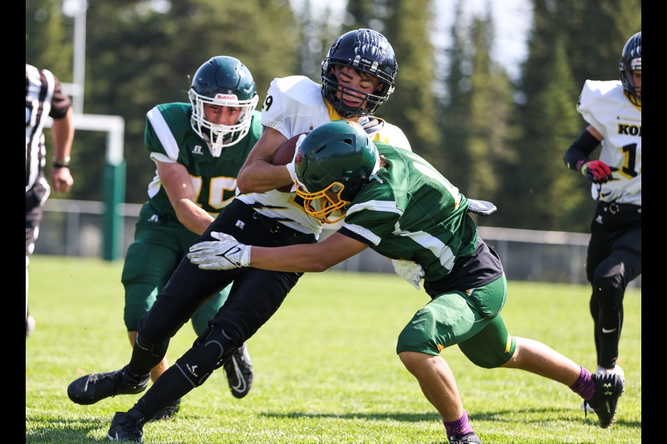Canmore Wolverines Tristan Drouin, left, and Nikko Breymann tackle a Carstairs Kodiaks player during the season home opener at Millennium Park in Canmore on Saturday (Sept. 7). JUNGMIN HAM RMO PHOTO