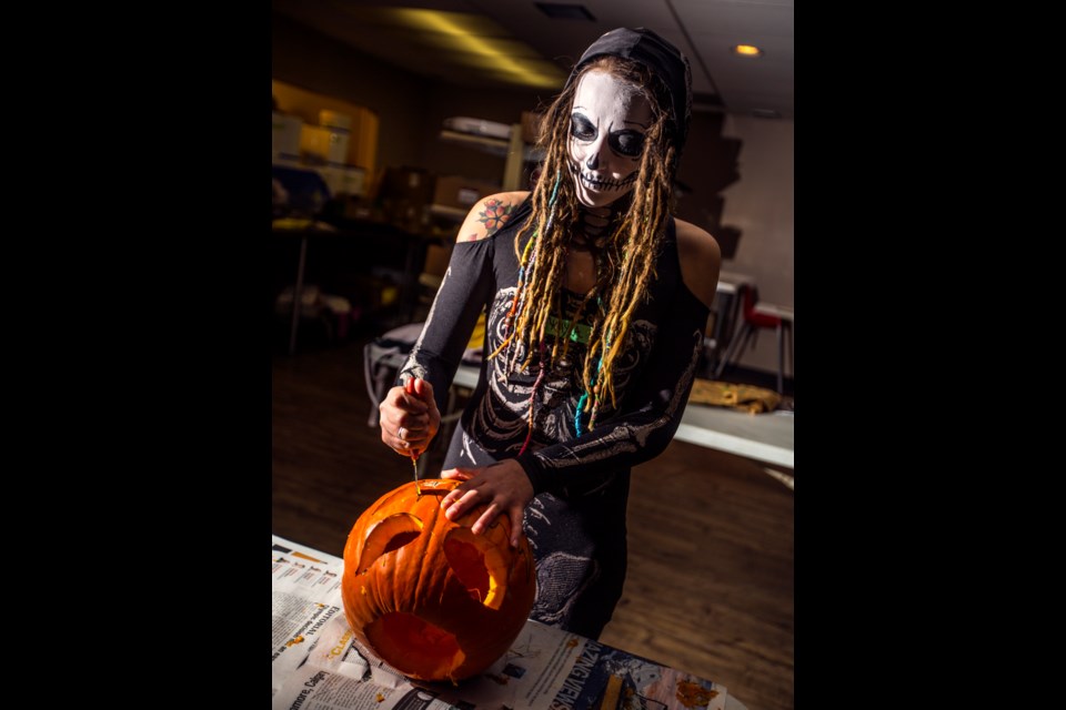 Kayla Roseler, a volunteer with the Canmore Young Adults Network, carves a pumpkin during the group's family Halloween night at the Canmore Legion in 2018. This year, CYAn is hosting pumpkin carving on Sunday (Oct. 27) at Origin in Spring Creek at 3 p.m. RMO FILE PHOTO