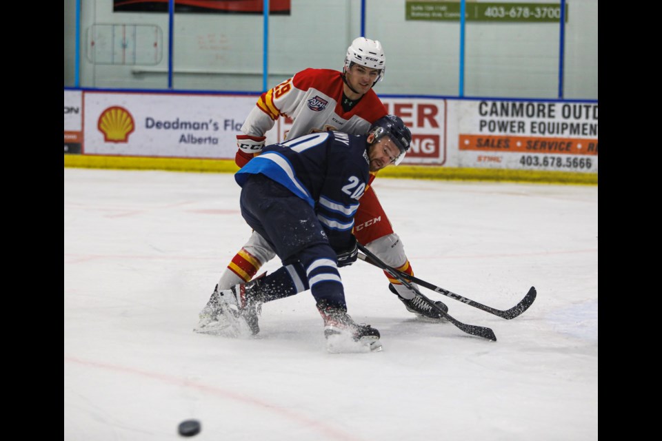 Canmore Eagles Riley Dekowny, front, battles a Calgary Canucks player for possession of a loose puck during the first period at the Canmore Recreation Centre on Friday (Oct. 28). JUNGMIN HAM RMO PHOTO