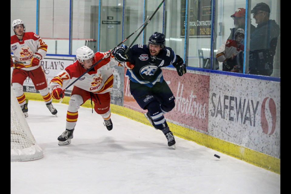 Canmore Eagles forward Kayden Smith, right, battles a Calgary Canucks player for possession of a loose puck at the Alex Kaleta Arena inside the Canmore Recreation Centre on Friday (Oct. 28). The Eagles beat the Canucks 5-3. JUNGMIN HAM RMO PHOTO