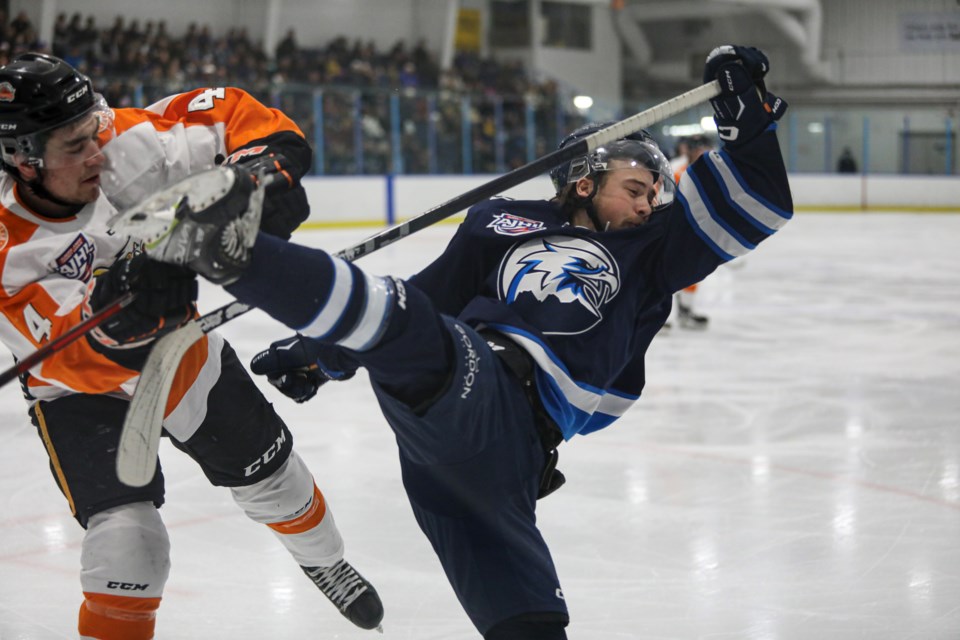 Canmore Eagles forward Rhett Dekowny gets body checked into the boards by Drumheller Dragons defenceman Cyle Clayton during Game 4 at the Canmore Recreation Centre on Wednesday (March 15). JUNGMIN HAM RMO PHOTO