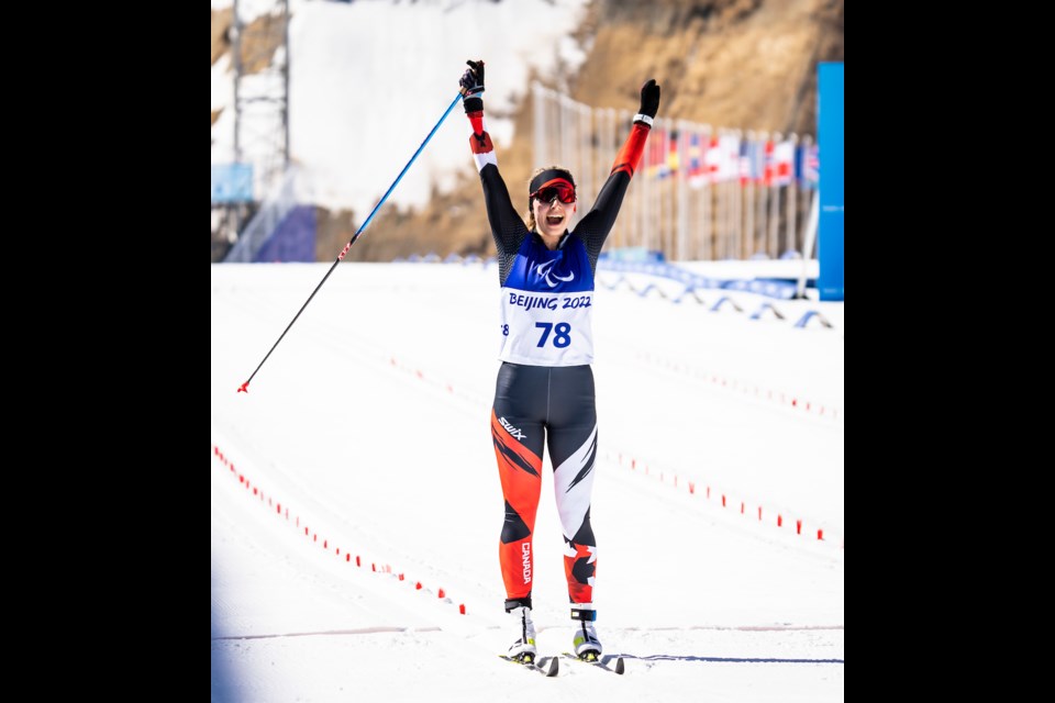 Natalie Wilkie throws her arms in the air crossing the finish line at the Beijing 2022 Winter Paralympic Games at the Zhangjiakou Biathlon Centre. DAVE HOLLAND CANADIAN PARALYMPIC COMMITTEE PHOTO