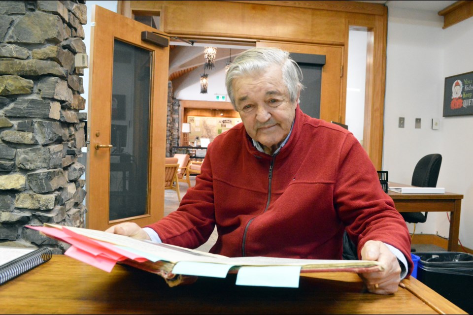 Chic Scott reads from one of the Calgary Mountain Club's old guidebooks of first ascents that he recently donated to the Whyte Museum of the Canadian Rockies in Banff. JORDAN SMALL RMO PHOTO