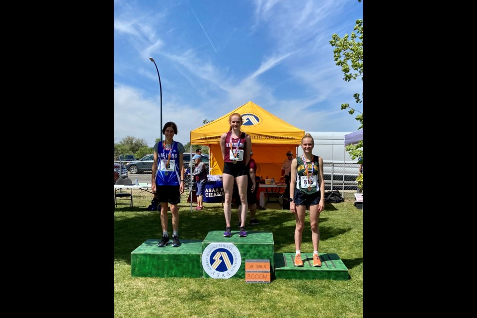 Canmore long distance runner Kahlen Anderson, right, stands on the podium at the 2022 ASAA Provincial Track and Field Championships in Medicine Hat. SUBMITTED PHOTO