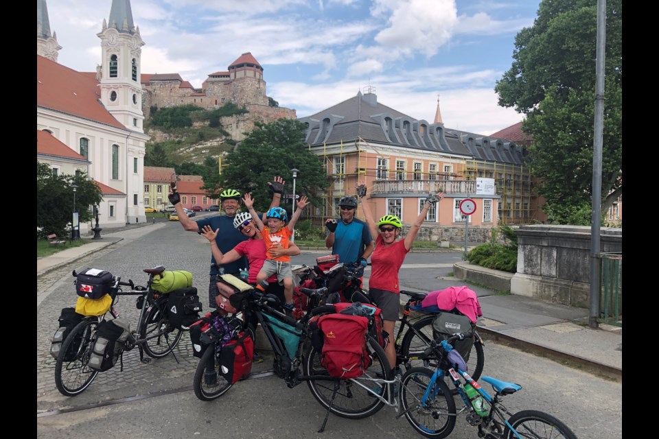 From back row left, Tony Teunis, Mike Rosen and Donna Teunis, with Katrina Rosen (centre) holding her son, Zion 6, celebrate after crossing the bridge from Slovakia into Hungary at the town of Esztergom, marking 3,000 kilometres travelled by bike across Europe. 
SUBMITTED PHOTO