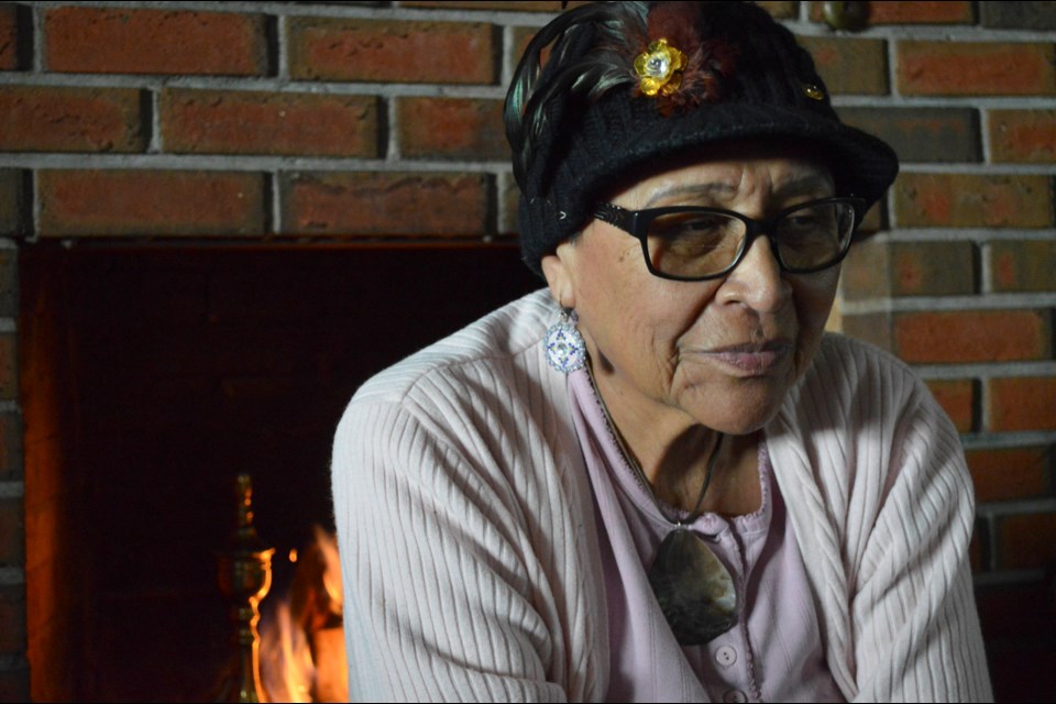 Elder Rhonda Kaquitts sits in front of her home's fireplace. The power at Kaquitts home was cut after she was sent a Notice to Vacate letter from the Chiniki band of the Stoney Nakoda First Nation. JORDAN SMALL RMO PHOTO
