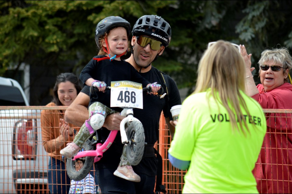 Canmore's Marcus Henry carries daughter Hope across the finish line in the U5 Little Critters race at the Rundle Mountain Road Festival on Saturday (June 4) in Canmore. JORDAN SMALL RMO PHOTO