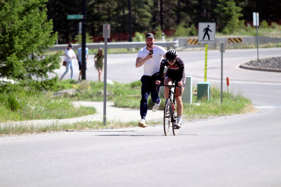Canadian Olympic speed skating gold medallist Isabelle Weidemann cruises to victory in the women's Cat 4 race, with coach Remmelt Eldering keeping pace and recording the moment on a smartphone in the last few metres, at the RMCC Road Festival on Sunday (June 4) in Canmore. JORDAN SMALL RMO PHOTO