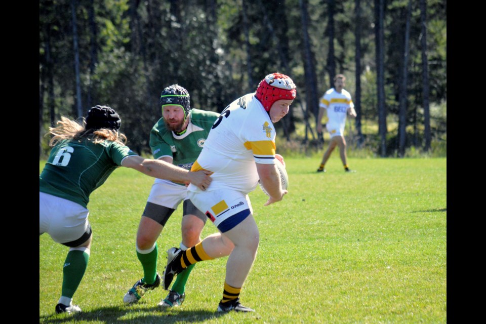 Banff Bears Ossi Treutler powers past a couple Calgary Irish defenders during the final game of the rugby men's season on Saturday (Sept. 9) at Banff Recreation Grounds. JORDAN SMALL RMO PHOTO