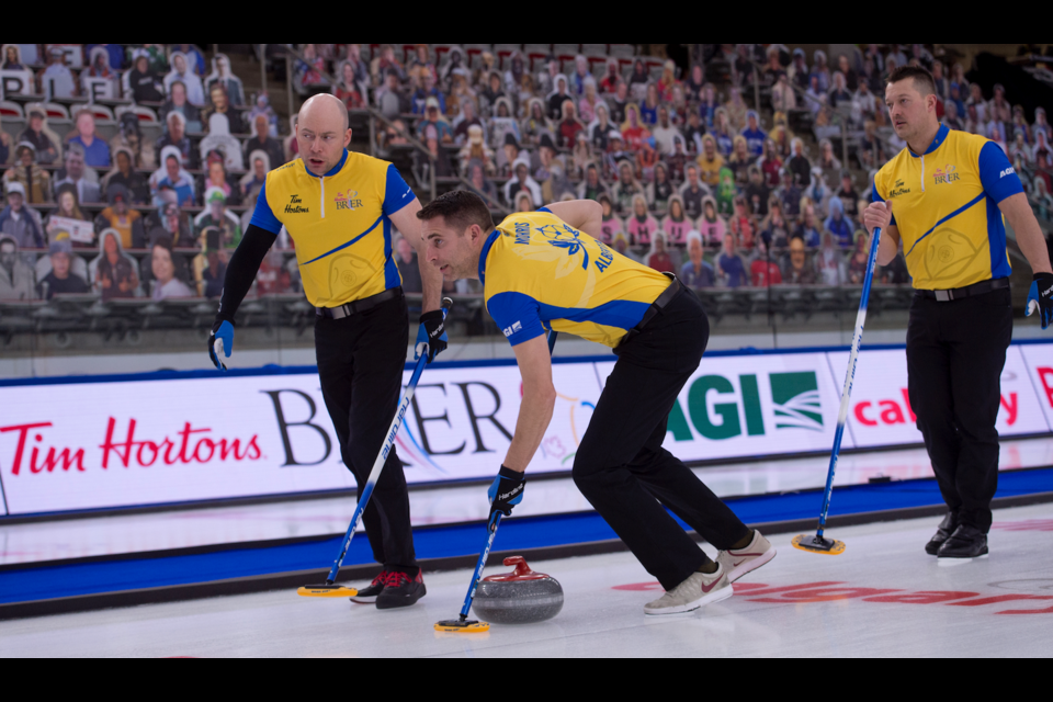John Morris, centre, of Team Kevin Koe sweeps during the 2021 Brier in Calgary. CURLING CANADA PHOTO