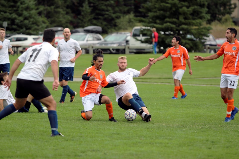 Rundle FC's Hector Navarro, left, and Canmore United's Brett Appleton go for the ball during the teams' match up at Millennium Field in Canmore on Sunday (Aug. 8). JORDAN SMALL RMO PHOTO