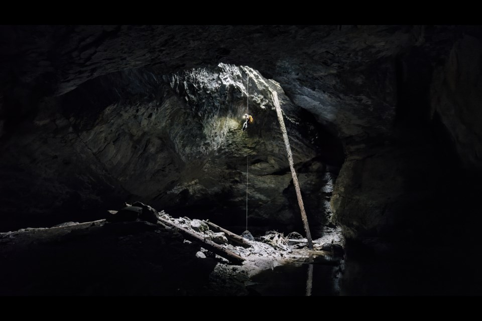 A caver descends on a thin line into a gaping cavern in search of the longest cave in Canada. PHOTO COURTESY OF SUBTERRANEAN