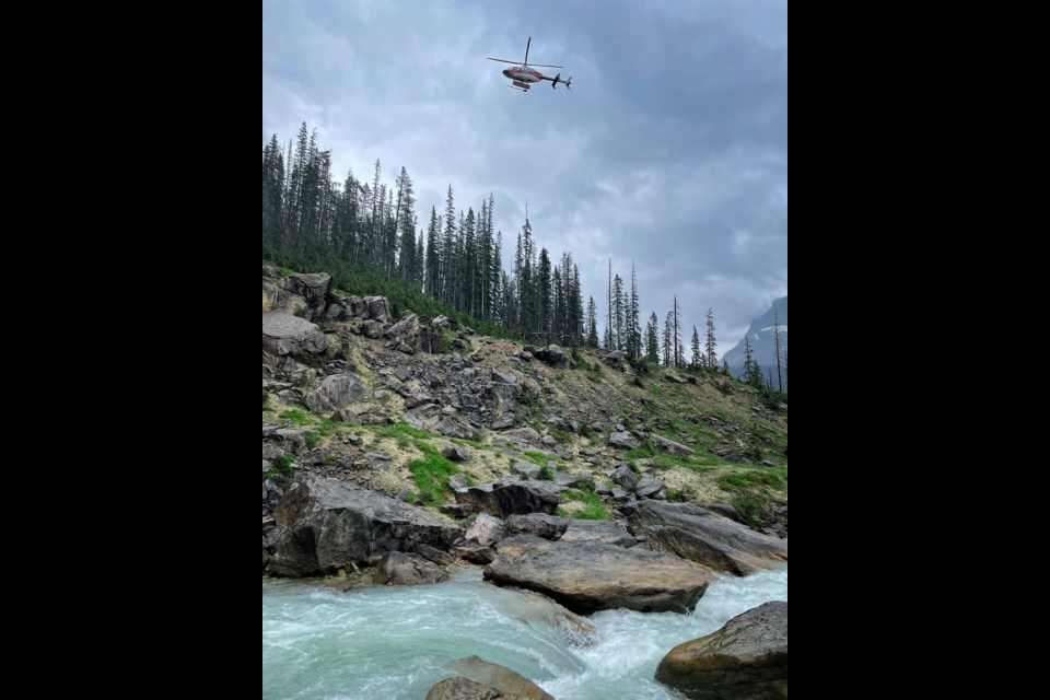 An Alpine Helicopter and Parks Canada rescuers search for a man who fell into the water at the base of Takakkaw Falls near Field, B.C. on Friday (June 16). Contributed photo