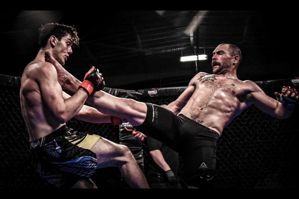 Canmore’s Adam Zekry, right, hits John Moore with a push kick during his amateur mixed martial arts debut at Rumble In The Cage 62 on Saturday (Oct. 19) in Lethbridge. ANETT MESZAROS AM TO PM PHOTOGRAPHY