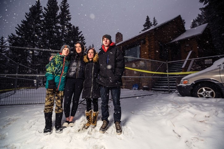 Quintin Lyon, 12, left, along with Ella, 16, mother Nicole and Nicholas, 19, stand outside their burned home in Banff on Tuesday (Jan. 9). The family was forced to evacuate