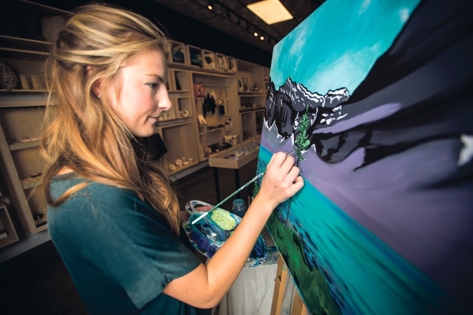 Kayla Eykelboom paints at Project A during Canmore Winter Carnival art walk artist demonstrations on Sunday (Feb. 4). Eykelboom’s solo exhibit ‘Glacier Fed’ takes place