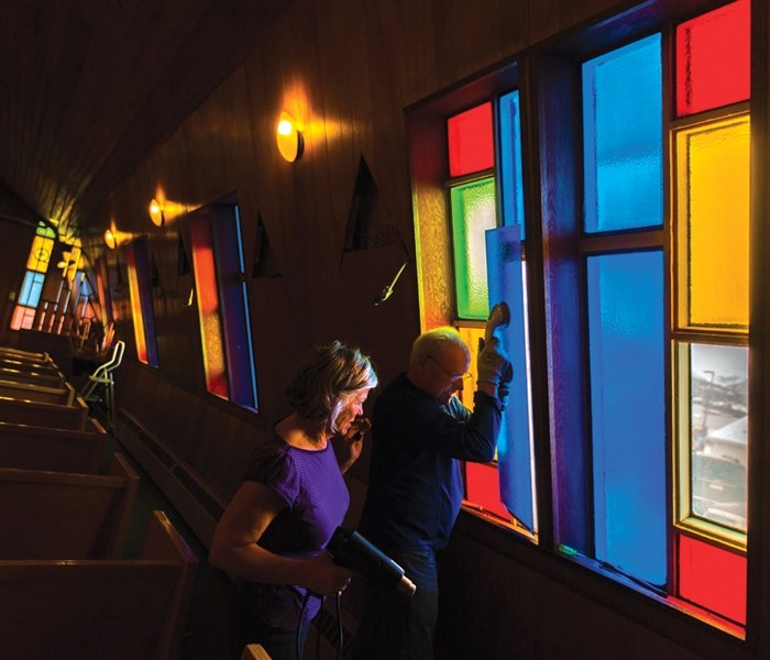 Robin Hemsing, left, and Steve Nolan remove stained glass windows as Sacred Heart Church is dismantled in Canmore on (Jan. 30).