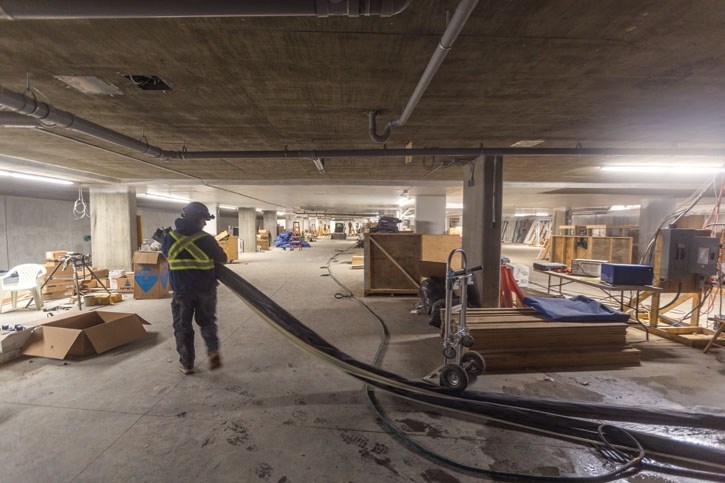 A worker pulls piping through the unfinished basement at the Coyote Lane housing project in Banff on Friday (Feb. 23).